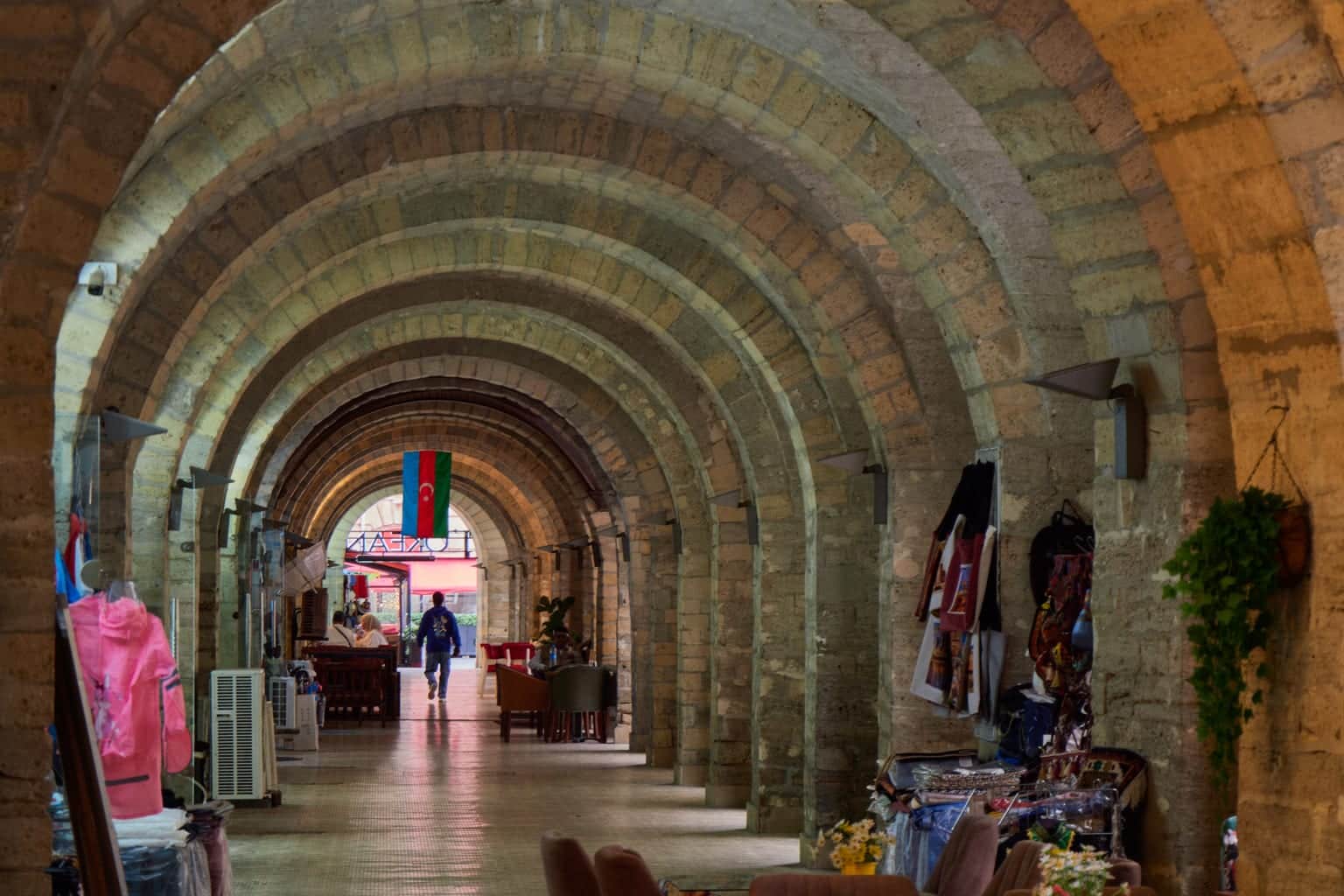 Vaulted stone arcade on Nizami Street in Baku, lined with souvenir stalls and a cafe