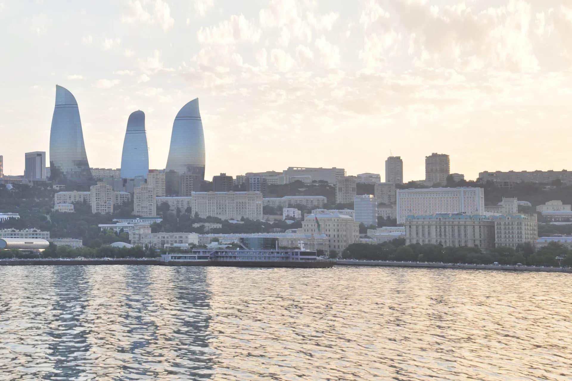 Baku waterfront and Flame Towers in the warm evening light across the Caspian