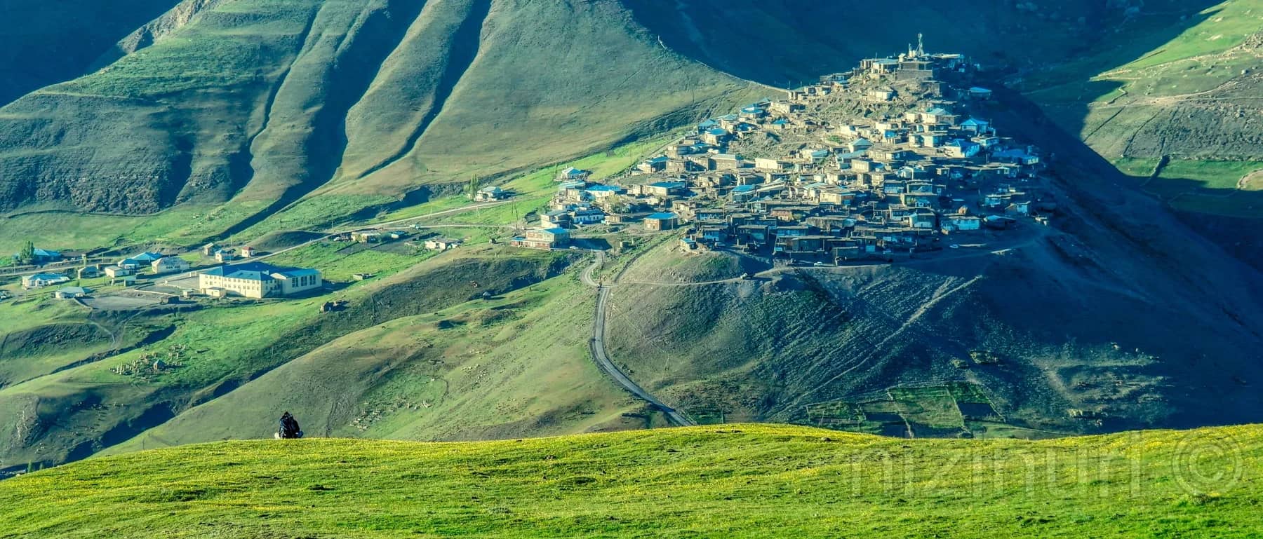 Khinalig village across a green mountain slope in Azerbaijan’s Greater Caucasus