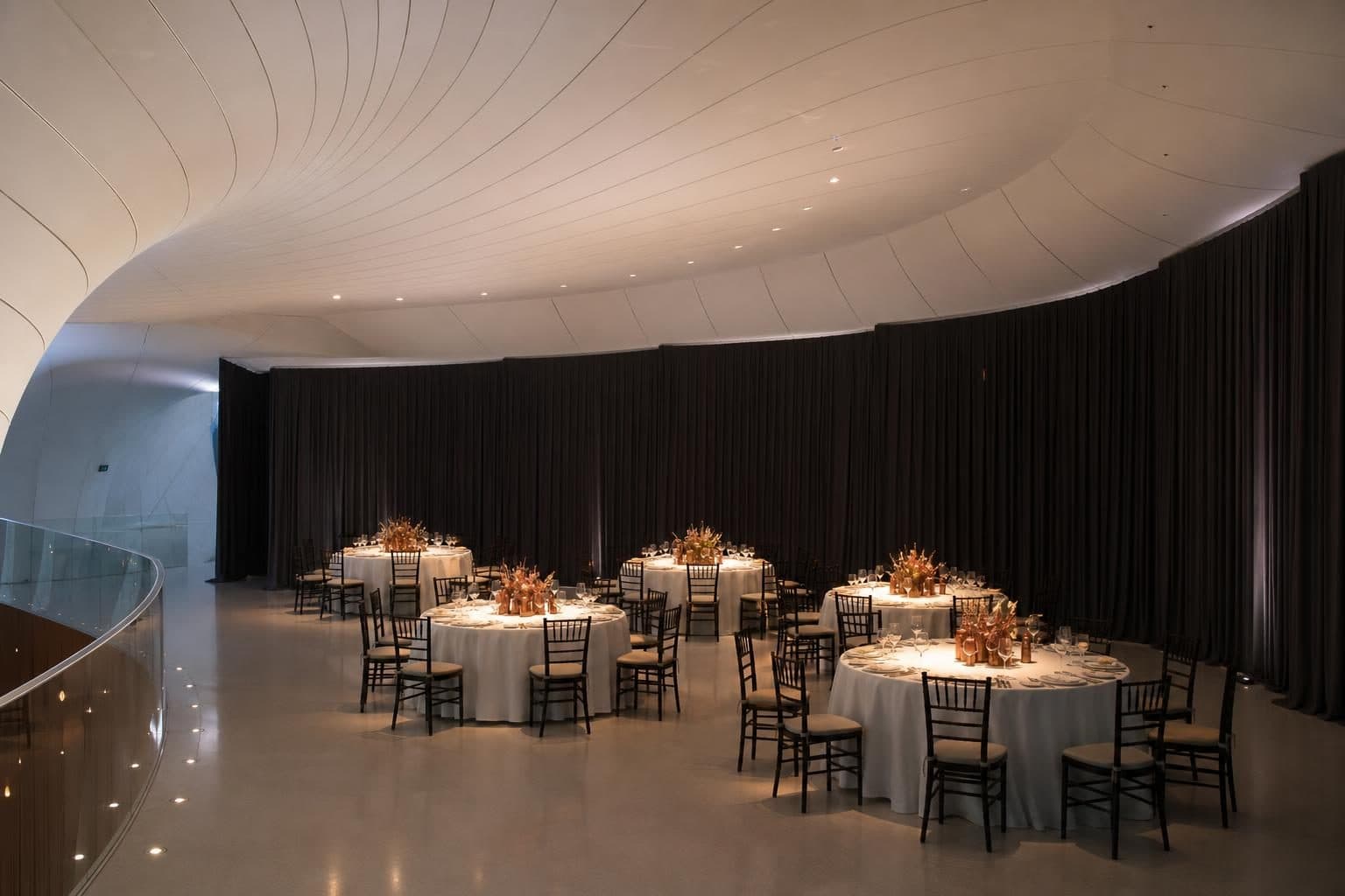 Six round tables with white linens, copper centerpieces, dark wood chairs, Heydar Aliyev Center, Baku