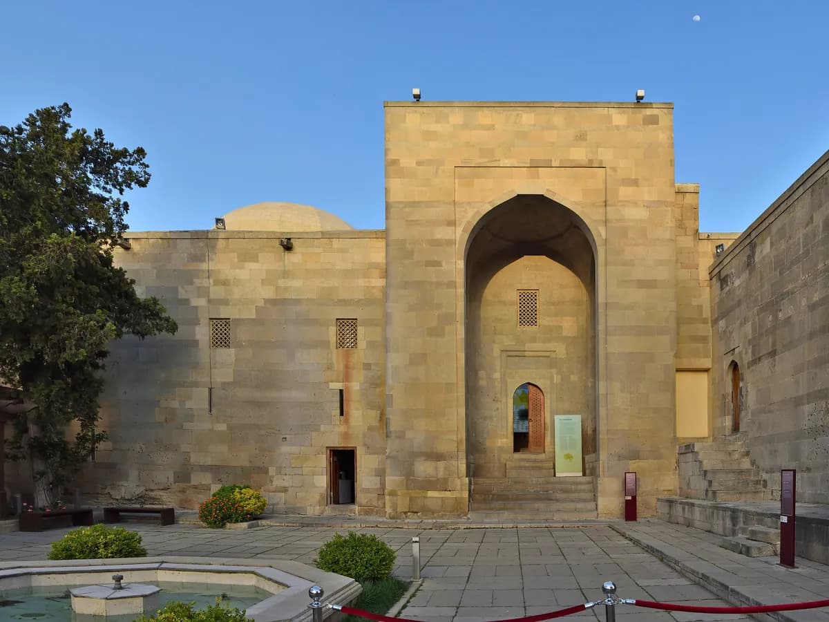 The tall arched entrance portal of the main palace building of the Palace of the Shirvanshahs, seen across its courtyard