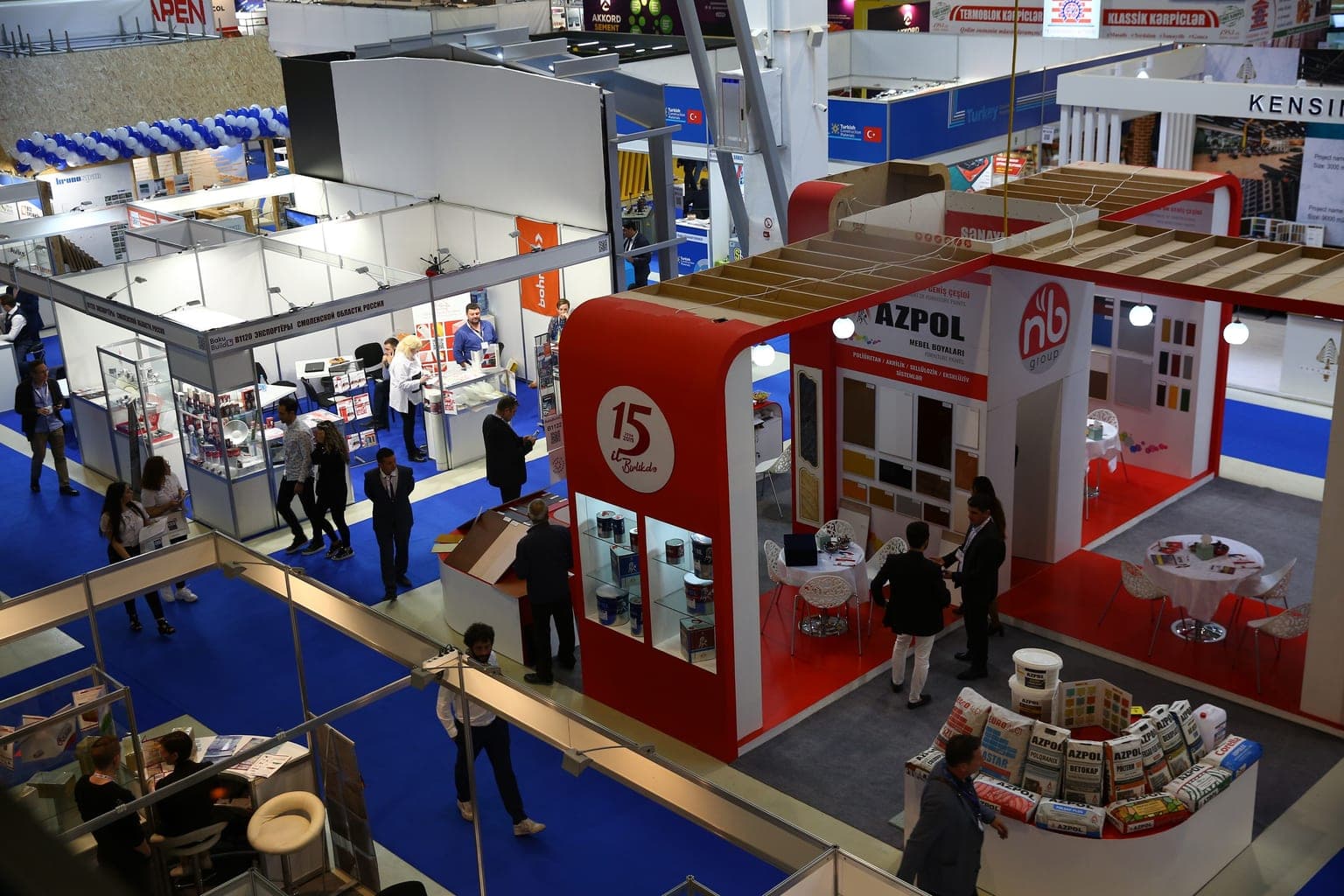Exhibition stands and visitors inside a Baku Expo Center hall during BakuBuild, seen from the mezzanine