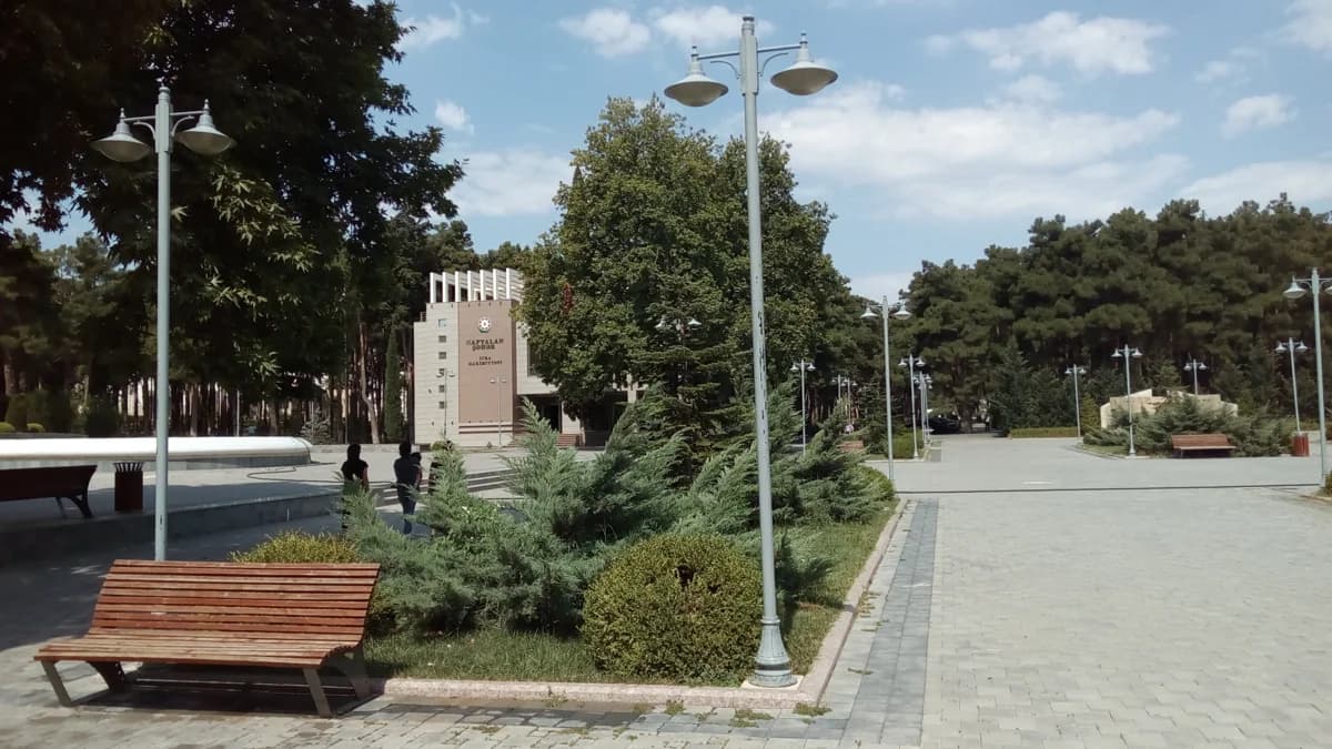 Tree-lined park walkway with benches and lamps in Naftalan, Azerbaijan, photographed in 2017