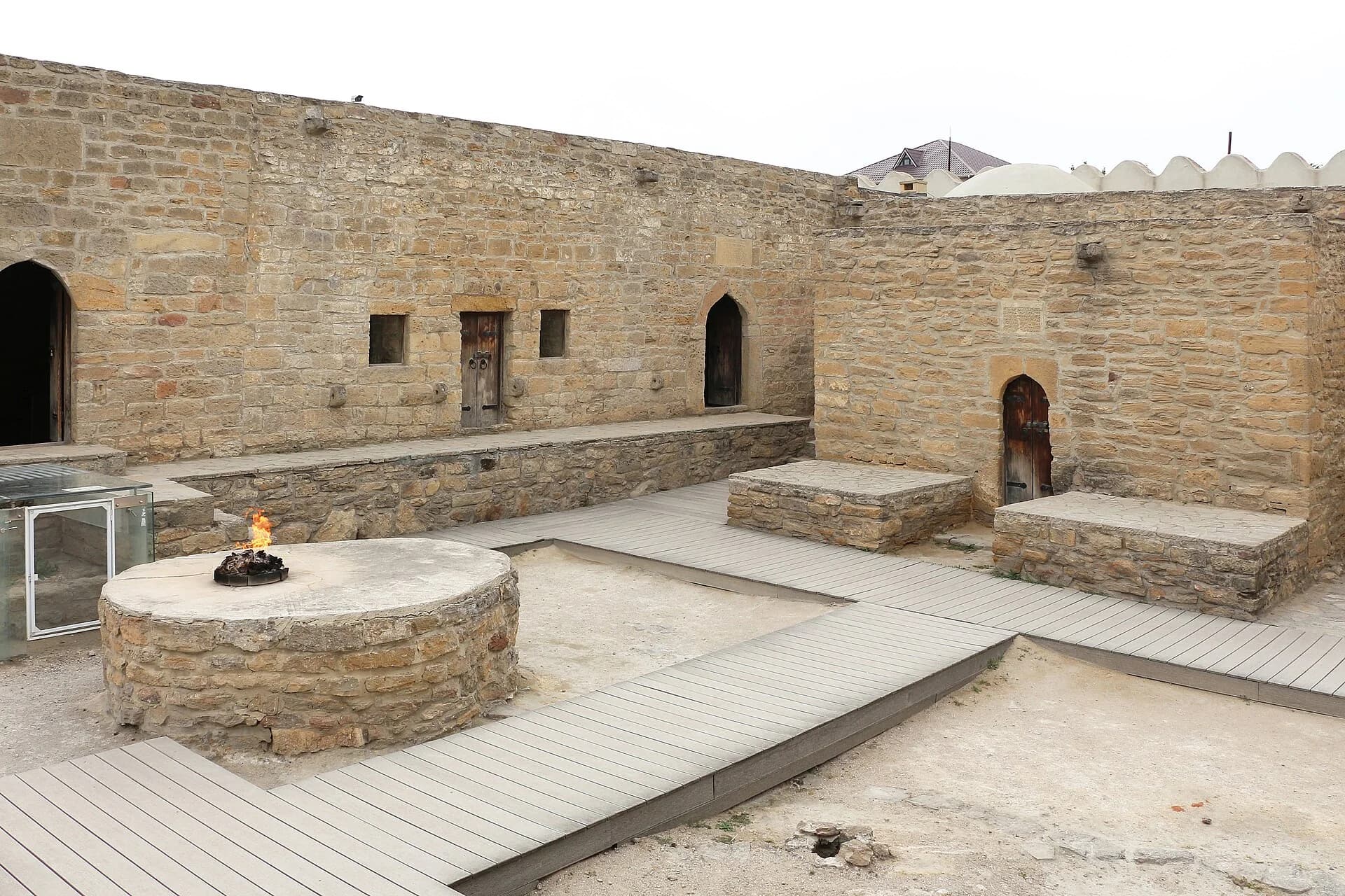 Stone courtyard and flame display at Ateshgah Fire Temple in Surakhani