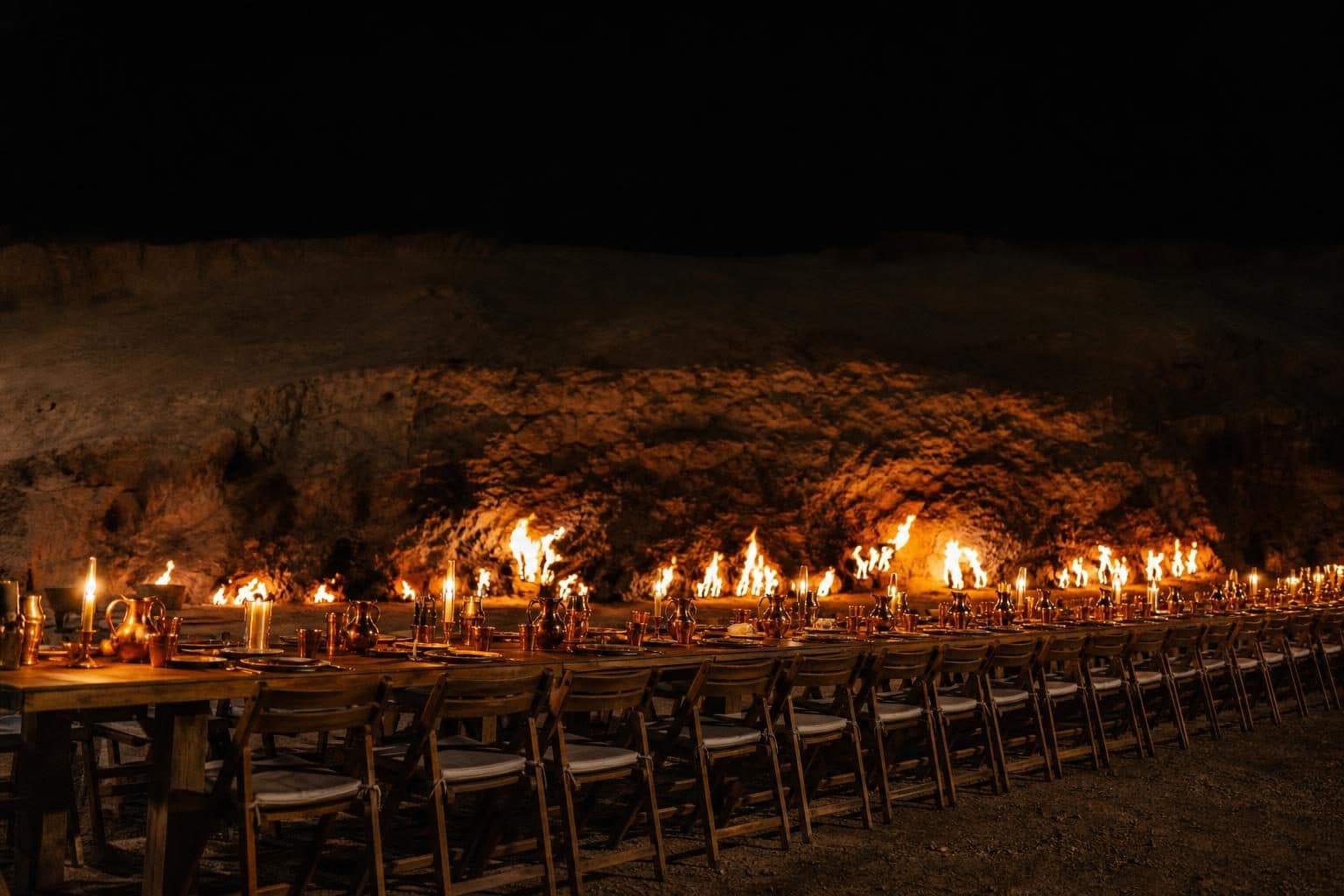 Long communal wooden table for 50 across frame, copper tableware, beeswax candles, Yanardag, Baku