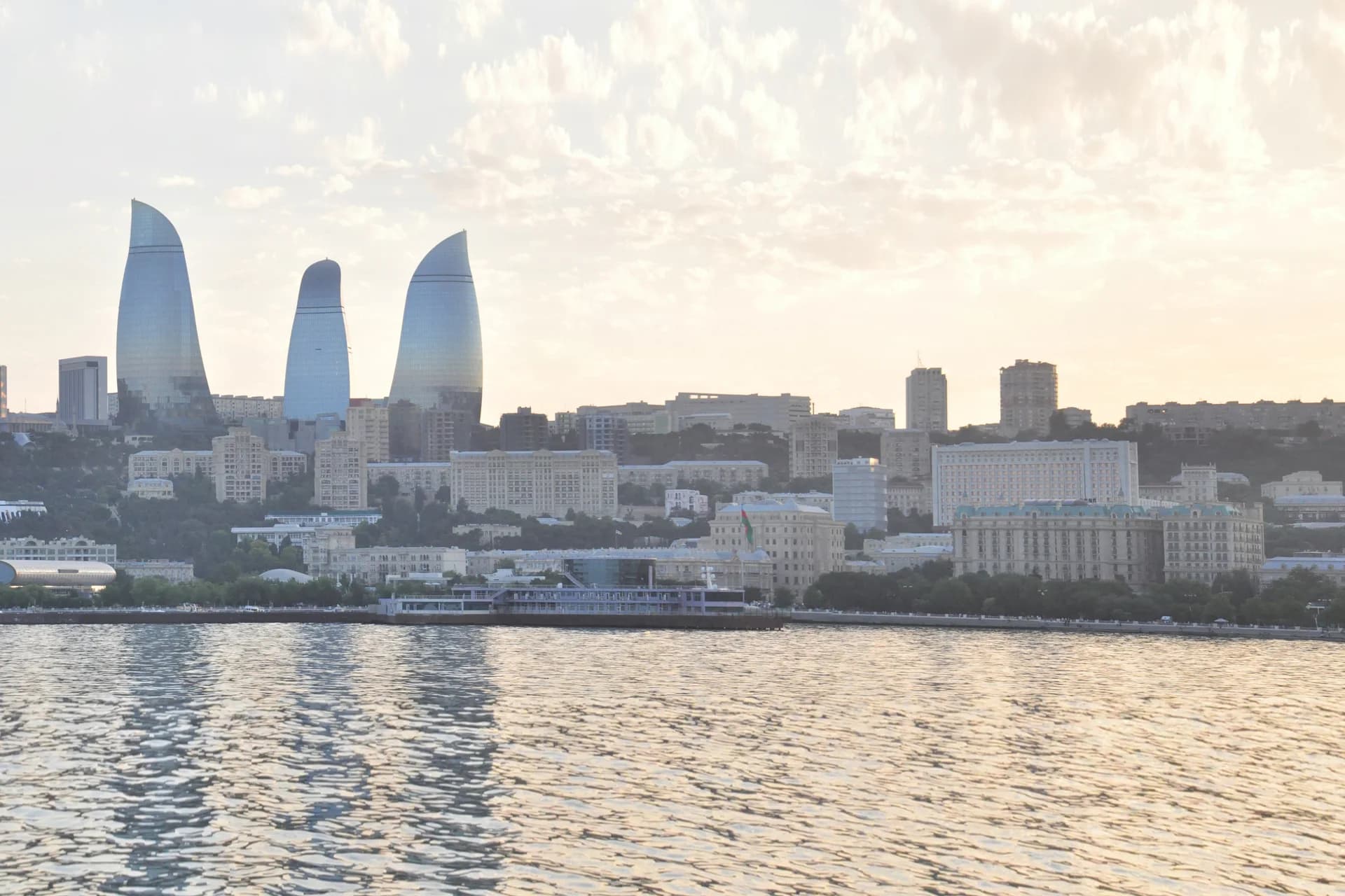 Baku waterfront and Flame Towers in the warm evening light across the Caspian