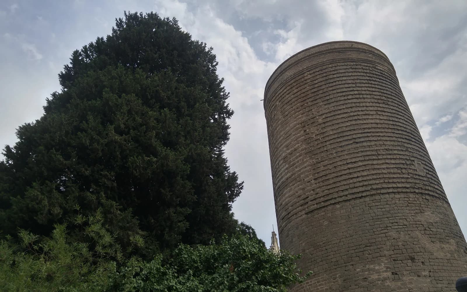 Maiden Tower in Baku Old City behind a large tree