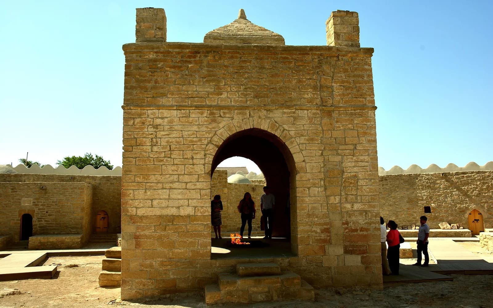 Stone fire altar at Ateshgah Fire Temple with visitors