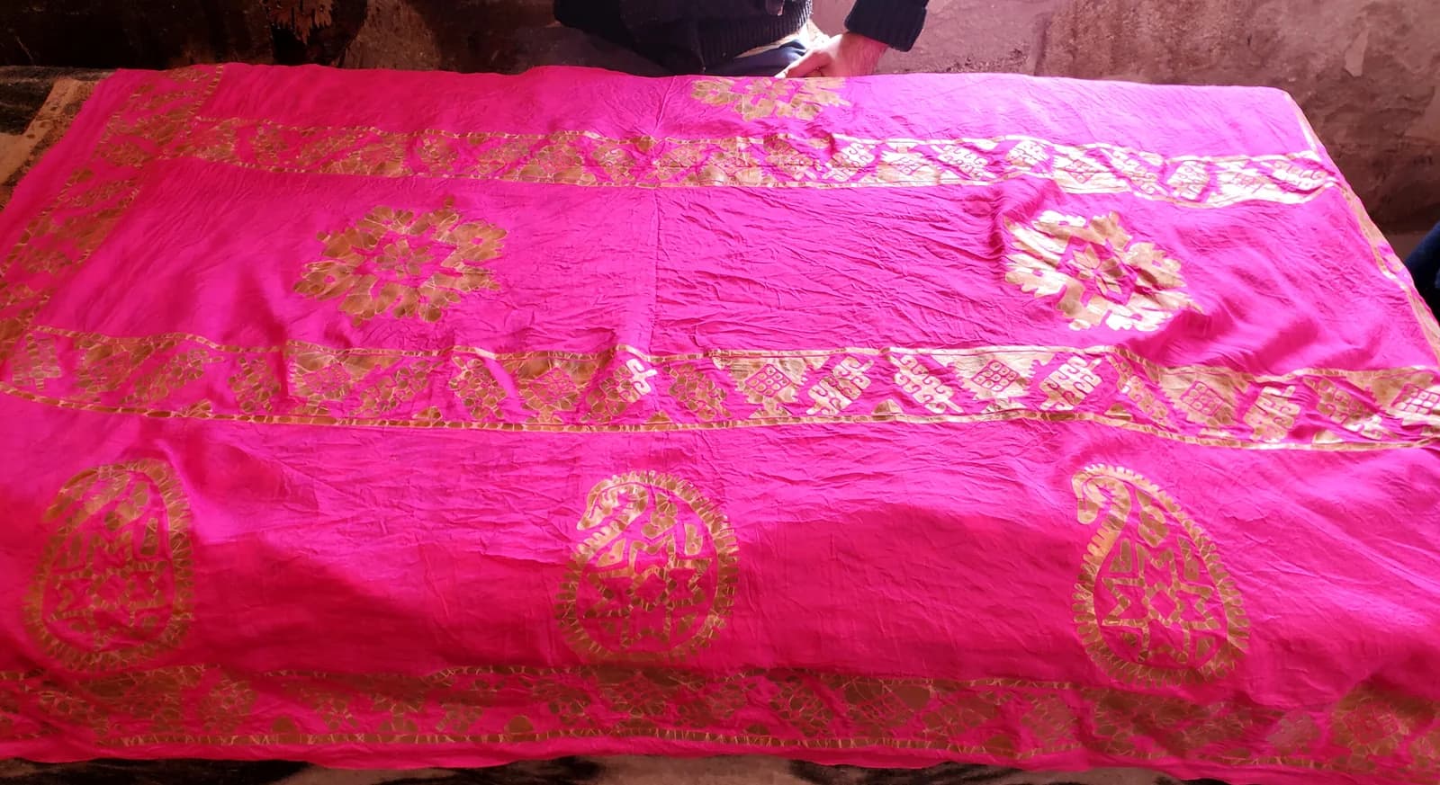 Pink kelaghayi silk scarf being decorated in a craft workshop