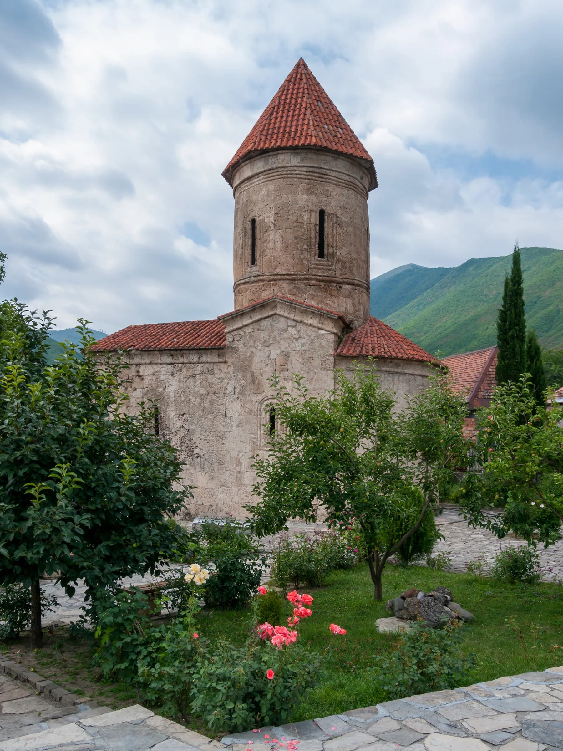 Stone church tower and garden in Kish village