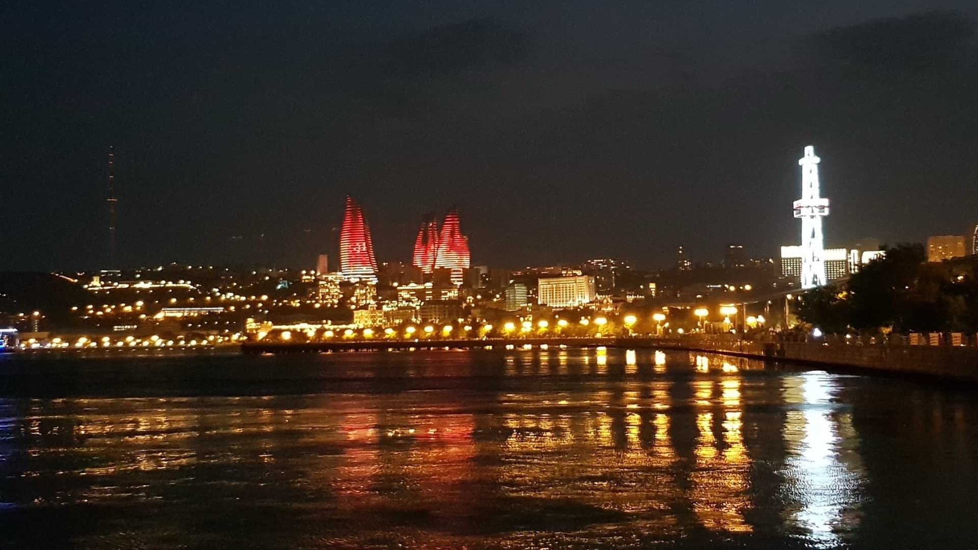 Baku Flame Towers illuminated at night against the Caspian skyline
