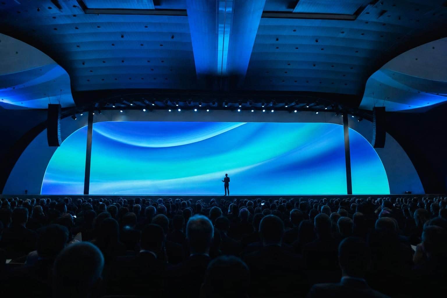 320 audience seen from back of room, single speaker on lit stage, Baku Convention Center