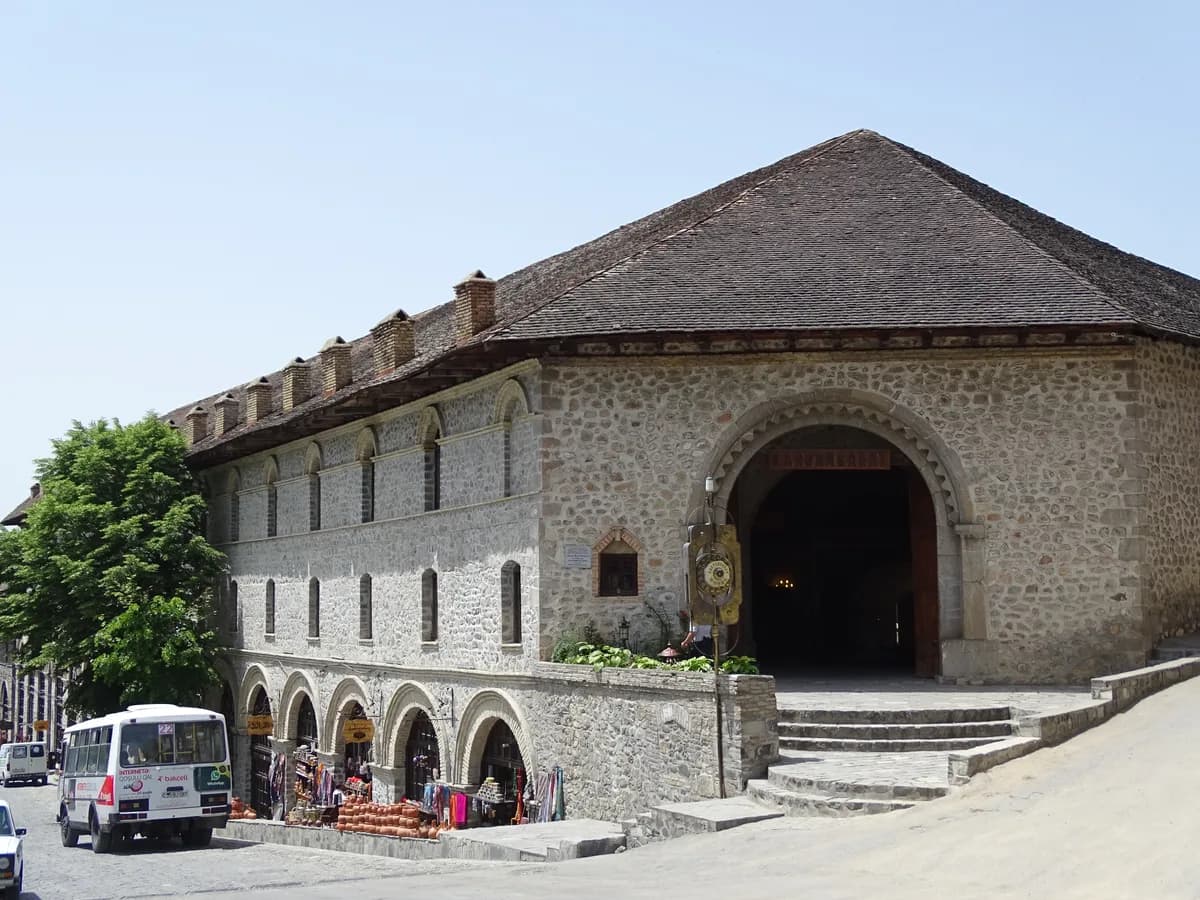 The stone street facade of the Sheki Caravanserai and its single arched gate
