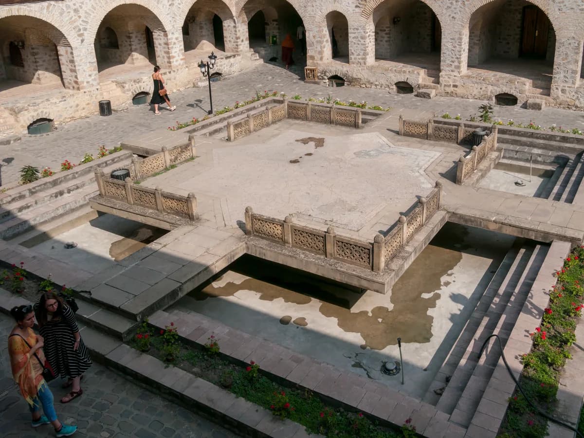The raised stone platform and water channels in the courtyard of the Sheki Caravanserai