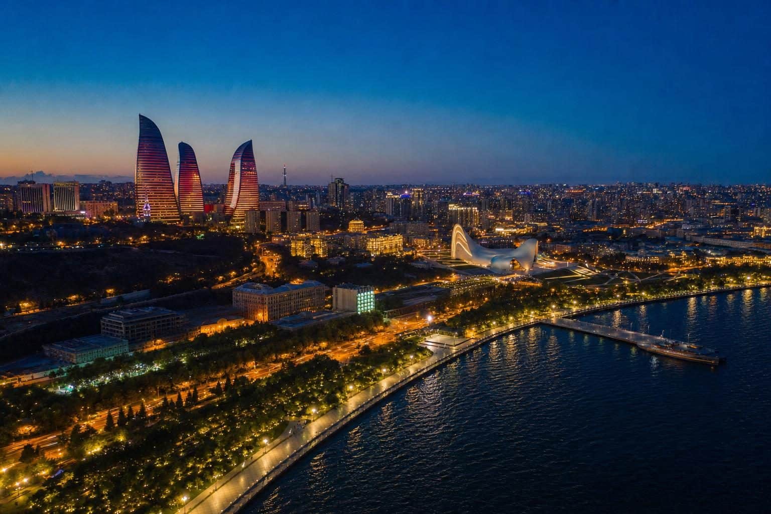 Flame Towers prominent left side, LED facades casting warm amber, Baku