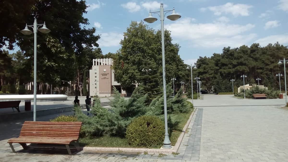 Tree-lined park walkway with benches and lamps in Naftalan, Azerbaijan, photographed in 2017
