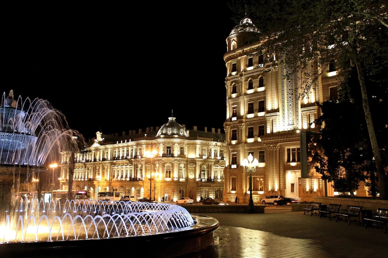 Illuminated fountain and buildings in central Baku at night