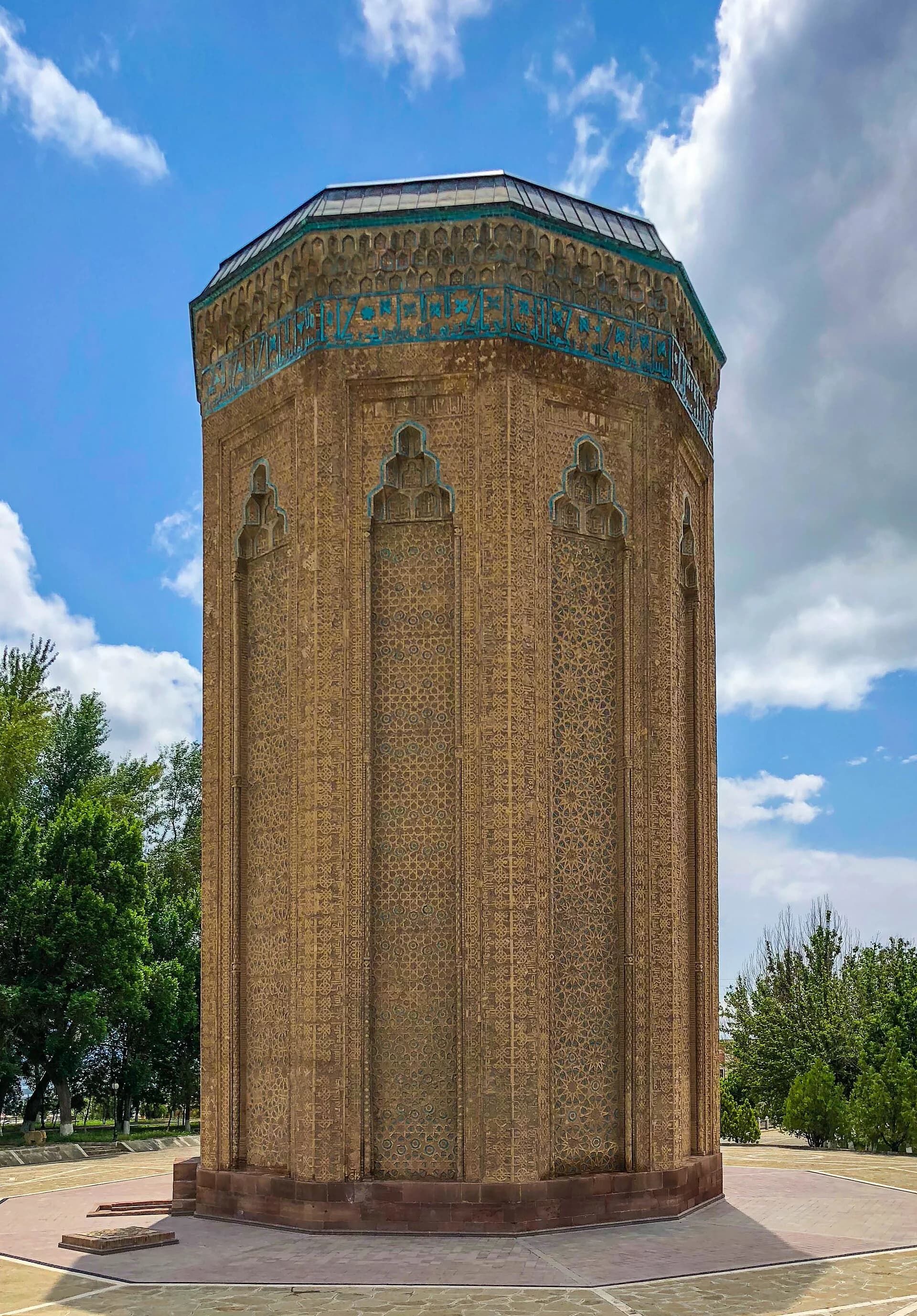 The patterned brick tower of Momine Khatun Mausoleum beneath a blue sky in Nakhchivan